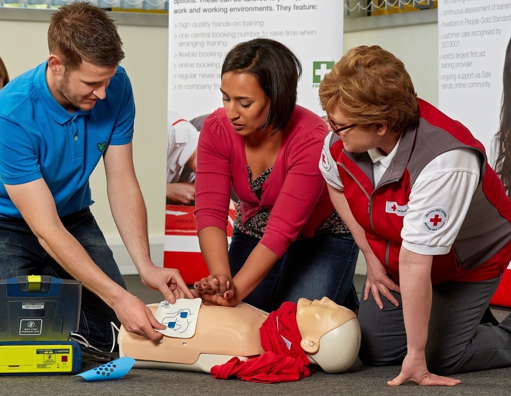 Group of colleagues being taught how to do CPR at a British Red Cross training session.