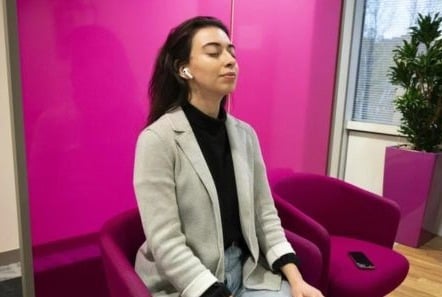 Woman sat in the office at work, taking a mindful moment.